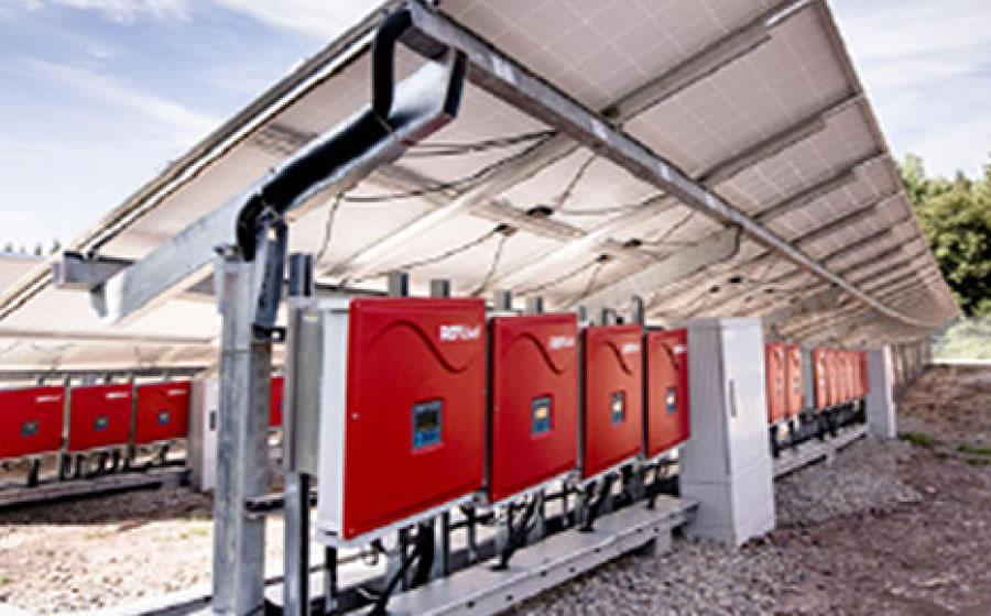 Melitron enclosure systems positioned underneath a series of solar panels.