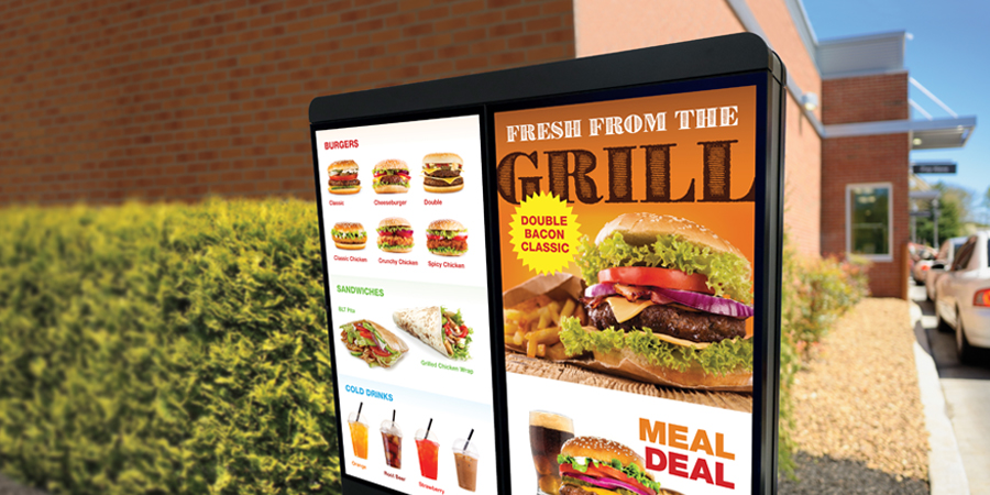 A Melitron outdoor digital menu board situated along a drive-thru.